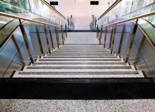 An example showing poor use of stair nosings. The light-coloured treads with black strips on the nosing create a marking pattern that is not perceived well by people impacted by blindness.