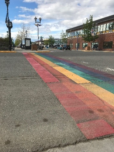 Crosswalkconsists of parrallel raibow-coloured strips without traditional white markings.